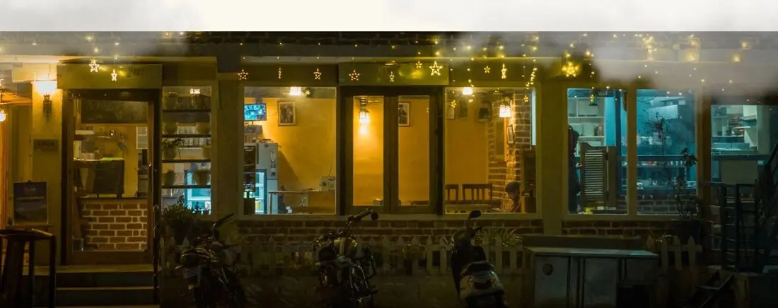 A café lit up at night with fairy lights